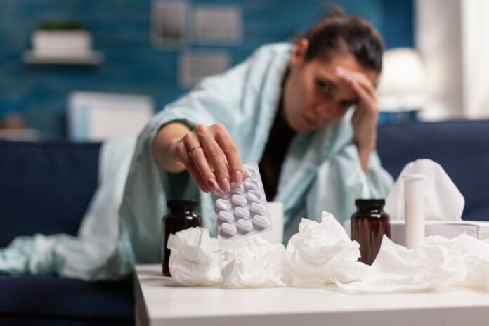 sick-woman-having-seasonal-illness-home-sitting-blanket-couch-young-adult-taking-medicine-medical-drugs-virus-cold-flu-disease-prescription-treatment-against-fever